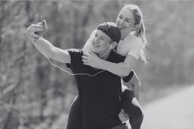 Happy couple taking a playful selfie outdoors – symbolizing Taurus and Cancer zodiac compatibility through emotional security, affection, and trust